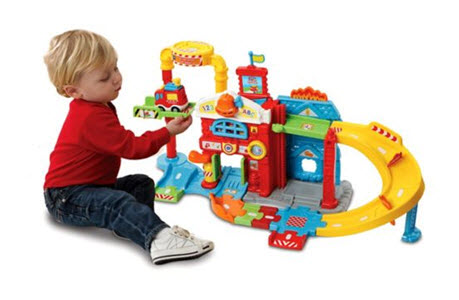 Child playing with Vtech Toot Toot Drivers Fire Station 